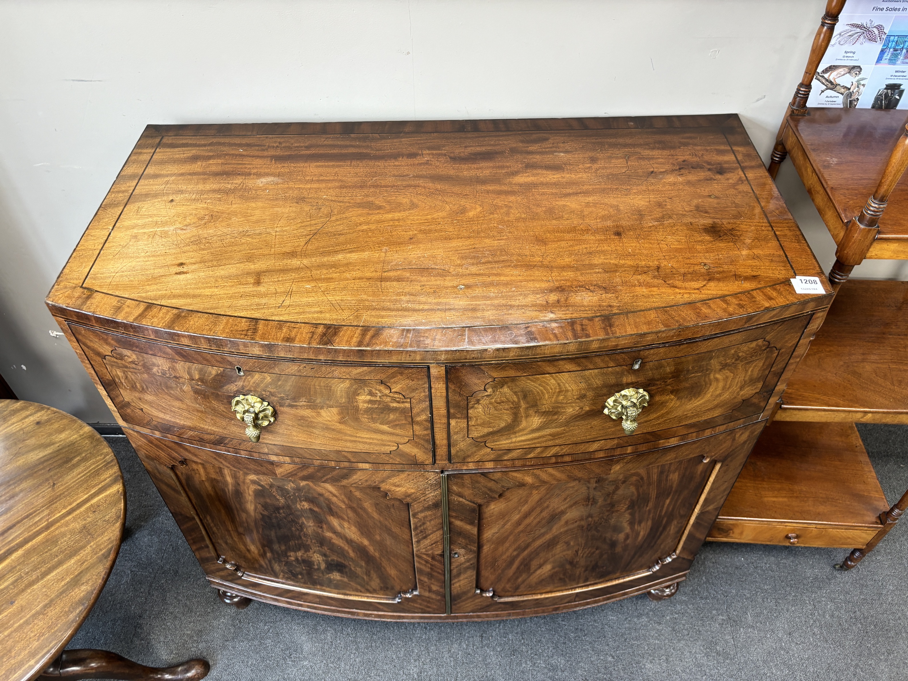A George IV flame mahogany bowfront press cupboard, width 115cm, depth 61cm, height 108cm